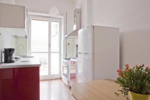 una cucina con frigorifero bianco e tavolo in legno di Garden House Holidays a Roma