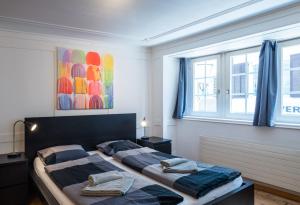 a bedroom with two beds and two windows at HITrental Niederdorf - Apartments in Zurich