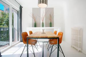 a dining room with a wooden table and orange chairs at Genteel Home Chueca in Madrid