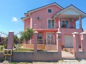 ein rosa Haus mit einem Zaun davor in der Unterkunft Casa Eric in Baile Felix