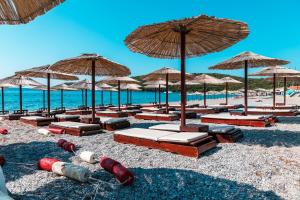 a beach with chairs and umbrellas and the ocean at Apartments Horizont in Budva