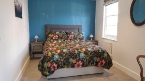 a bedroom with a bed with a floral bedspread at Argyll House Bed and Breakfast in Westleton