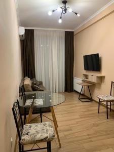 una sala de estar con una mesa y sillas de cristal en Melikishvili str. apartment, en Tiflis