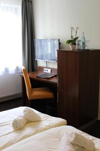 a bedroom with a desk and a bed and a computer at Hotel Brantl in Roding