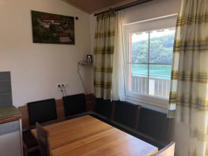 a dining room with a table and a large window at Seeblick in Döbriach