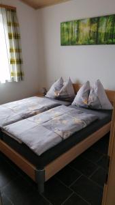 a large bed in a bedroom with at Seeblick in Döbriach