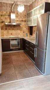 een keuken met een roestvrijstalen koelkast en een wastafel bij Arcadia Palace Apartments with Sea View in Odessa