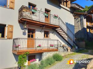 un edificio con 2 balcones y una escalera en Charmant appartement de 50m2 pour 2 personnes - terrasse et balcon en Courchevel