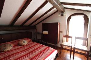 una camera con un letto e una sedia e una finestra di Captivating 4 -Bed Apartment in Bellagio Historic a Bellagio