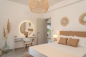 a white bedroom with a large bed and a mirror at Villa Makrilis in Karterados +37 photos