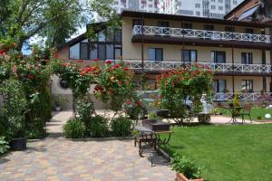 um jardim com flores e um edifício ao fundo em Апартаменти Маяк em Odessa