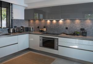 a kitchen with white cabinets and stainless steel appliances at Villa Soligia Blue in Pefkali
