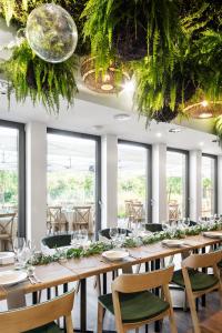 HERBARIUM boutique hotel في أولوموك: غرفة طعام مع طاولات وكراسي ونوافذ