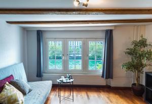 a living room with a couch and windows at HITrental Niederdorf - Apartments in Zurich