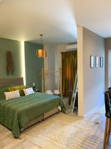 1 dormitorio con 1 cama con colcha verde en F.T.P Luxury Rooms, en Patra