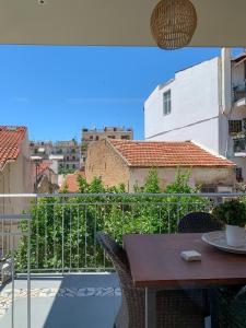 a balcony with a table and a view of a city at F.T.P Luxury Rooms in Patra