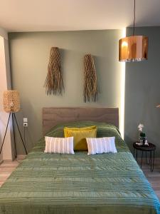 a bedroom with a green bed with two pillows at F.T.P Luxury Rooms in Patra