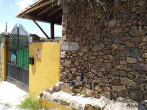 una pared de piedra junto a un edificio con una puerta en Atardecer en Gredos 2, en San Bartolomé de Tormes
