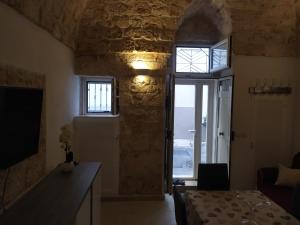 Zimmer mit einem Tisch, einem Fenster und einer Tür in der Unterkunft Soggiorno Galasso in Ostuni