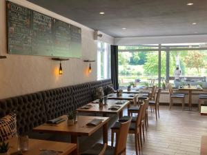 a restaurant with tables and chairs and a chalkboard on the wall at Hotel-Fritz in Valwig