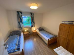 Cette chambre comprend 2 lits et une fenêtre. dans l'établissement Ferienhaus Frei 3 Budget, à Titisee-Neustadt