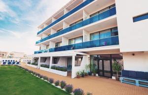 a large white building with blue balconies and a yard at Lavender Villa in Mamaia Nord