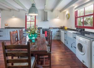 kuchnia ze stołem i krzesłami oraz pralnia w obiekcie Daisys Cottage Barnabrow w mieście Ballycotton