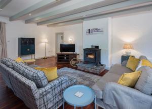 uma sala de estar com dois sofás e uma lareira em Daisys Cottage Barnabrow em Ballycotton