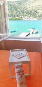 a small table with a book on it next to a window at Savić Apartments in Kotor
