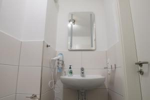 a white bathroom with a sink and a mirror at FeWo Engler Wallstraße W1 in Lüneburg