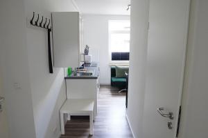 a white kitchen with a sink and a table at FeWo Engler Wallstraße W1 in Lüneburg