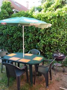 una mesa y sillas con una sombrilla en Minigarden Hause, en Eger