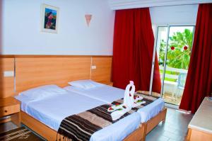 a bedroom with a bed and a window with red curtains at Thapsus Beach Resort in Mahdia +38 photos