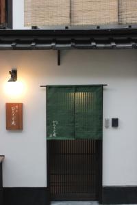 a door with a green sign on the side of a building at Kiyomizu Birodo-an in Kyoto +17 photos