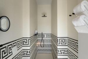 a bathroom with black and white tiled walls and a mirror at Zlata Ladjica Boutique Hotel in Ljubljana