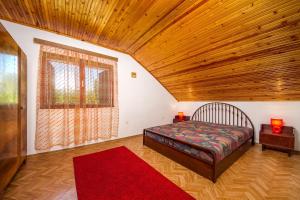 ein Schlafzimmer mit einem Bett und einer Holzdecke in der Unterkunft Familia nyaraló 16 in Balatonmáriafürdő