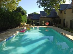 una piscina con sillas y una casa en La Demeure du Figuier, en Évran