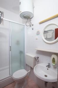 y baño con aseo, lavabo y espejo. en Villa Konalic, en Mokošica
