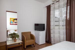 1 dormitorio con 1 cama, 1 silla y TV en Villa Konalic, en Mokošica