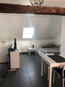 Zimmer mit einem Bett, einem Schreibtisch und einem Tisch in der Unterkunft Grand studio centre historique Sancerre in Sancerre