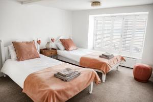 a bedroom with two beds and a window at Seaview on the beach in Port Erin