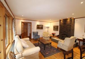 ネシー・ブリッジにあるLangrick - Tranquil home in Nethybridgeのリビングルーム(ソファ、椅子、暖炉付)