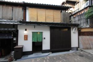 a white building with a gate and a green door at Kiyomizu Birodo-an in Kyoto