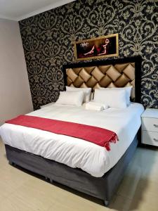um quarto com uma cama grande e um cobertor vermelho em 36 frere road shelly beach , margate em Margate