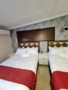 Duas camas sentadas uma ao lado da outra num quarto em 36 frere road shelly beach , margate em Margate