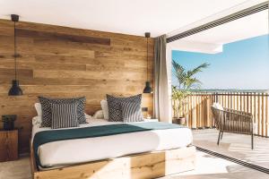 um quarto com uma cama e uma varanda em Las Gaviotas Suites Hotel & Spa em Playa de Muro