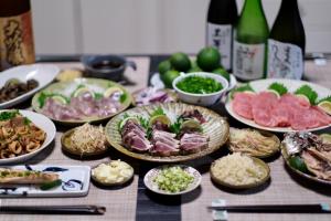 une table avec de nombreuses assiettes de nourriture dans l'établissement Shimanto Riverside Hideaway, à Shimanto