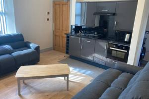 a living room with a couch and a table and a kitchen at The Annex Keith Self Catering WiFi Private Parking bkng in Keith