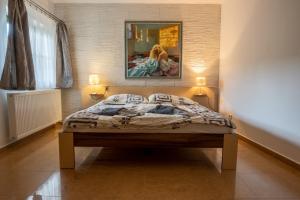 Pension Max Valtice في فالتيس: غرفة نوم بسرير مع لوحة على الحائط