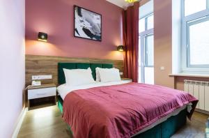 a bedroom with a bed with a pink wall at Partner Guest House Velyka Vasylkivska in Kyiv